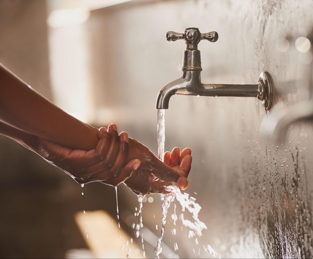 Washing hands thoroughly under clean, running water for effective sanitation.