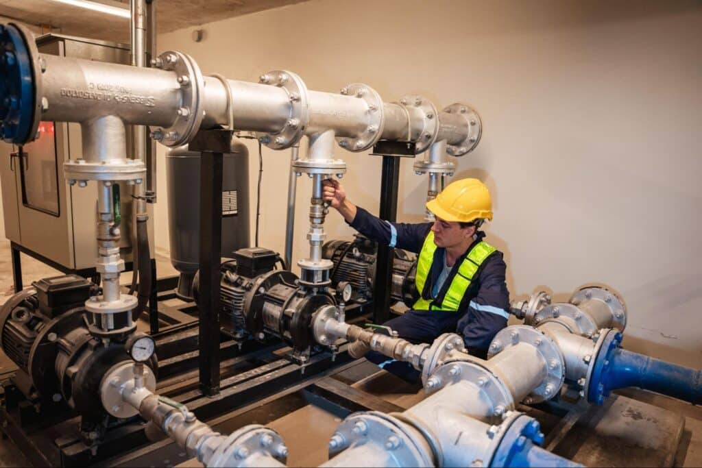 Pipe maintenance worker inspecting industrial piping system for optimal performance.