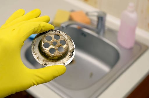 Cleaning a dirty sink drain for a fresh, clog-free kitchen.