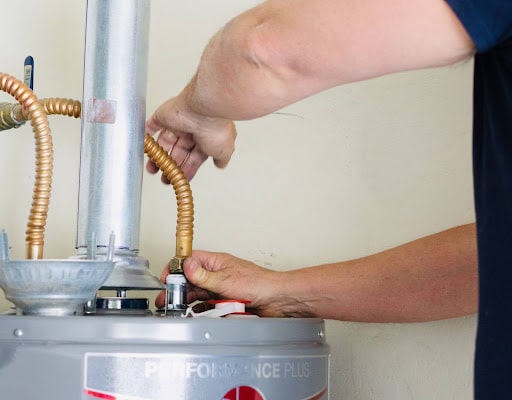 Professional water heater repair in progress with skilled hands adjusting the connections.