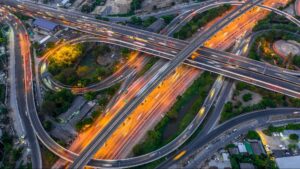 Aerial view of a busy highway interchange illuminated at night.