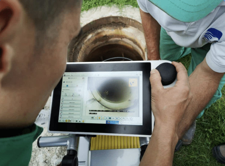 Technician using a tablet for efficient sewer line inspection and monitoring.