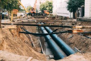 Underground construction site with large pipes and machinery for utility Pipe Relining project
