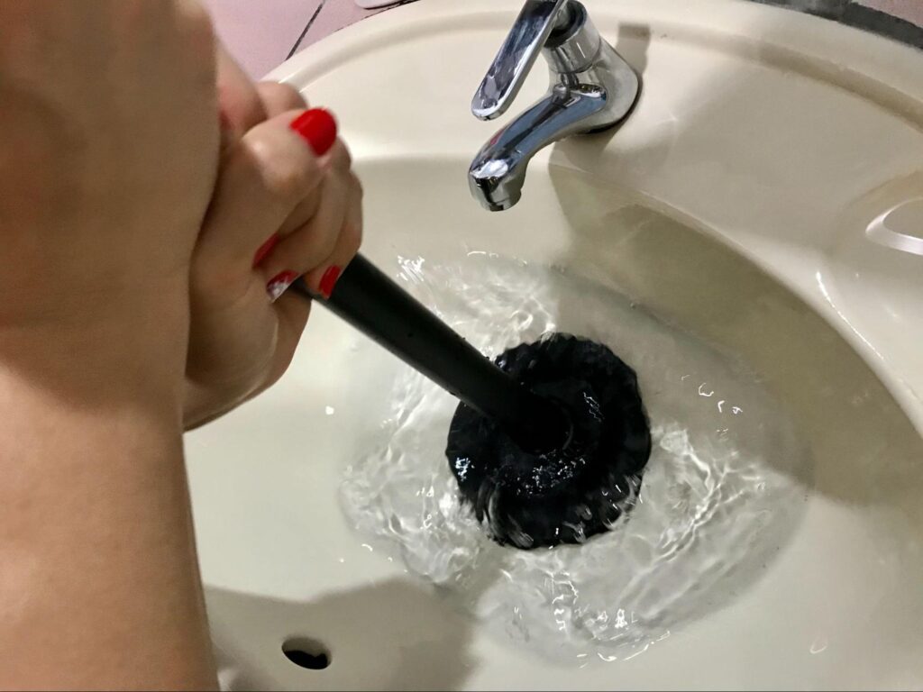 Effectively using a plunger to unclog a sink drain quickly.